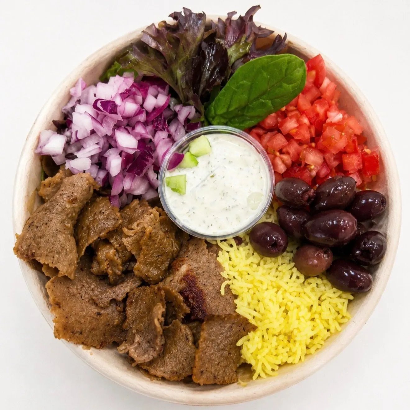 Gyro Crown bowl with beef and lamb gyro, red onion, tomato, olives, yellow rice and tzatziki